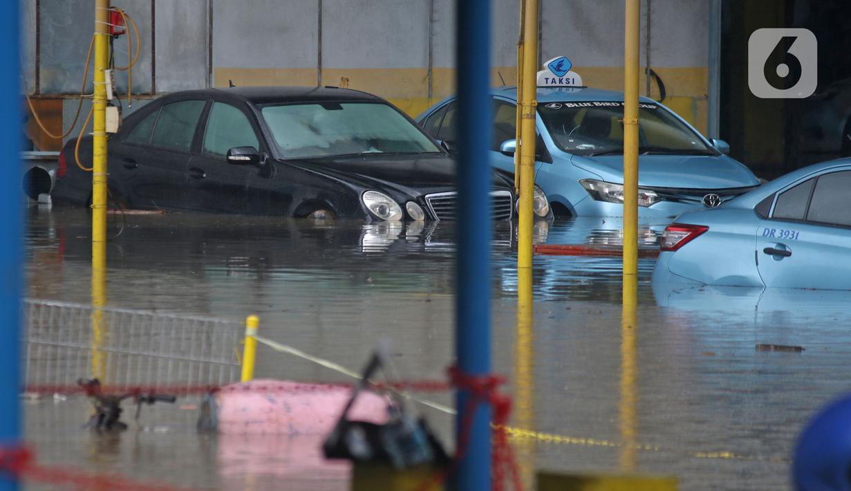 Sejumlah taksi terendam banjir di Pool Taksi Bluebird kawasan Kramat Jati, Jakarta, Selasa (25/2/2020). Meluapnya Kali Cipinang membuat Pool Taksi Blue Bird yang berada tepat di samping kali ikut terdampak banjir. (Liputan6.com/Herman Zakharia)
