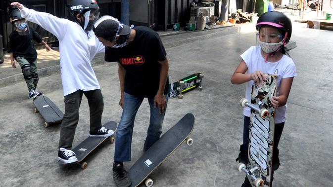 Sejumlah anak dengan menggunakan masker dan face shield berlatih skateboard di Crooz Shophouse di kawasan Duren Tiga, Jakarta Selatan, Minggu (2/8/2020). Sekitar tiga minggu ini mereka kembali melakukan latihan seminggu dua kali dengan menerapkan protokol kesehatan. (merdeka.com/Arie Basuki)