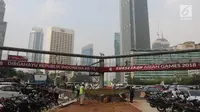Jembatan penyeberangan orang (JPO) terlihat menghalangi pemadangan Patung Selamat Datang di tengah Bundaran HI.Jakarta, Selasa (24/7). JPO tersebut akan dibongkar untuk mempercantik pemandangan saat Asian Games. (Liputan6.com/Arya Manggala)