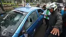 Pengendara ojek online merusak dan melakukan sweeping di kawasan Senayan, Jakarta, Selasa (22/3). Pascabentrok ojek online melakukan sweeping dan perusakan terhadap taksi serta bajaj yang melintas di kawasan tersebut. (Liputan6.com/Immanuel Antonius)