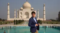 Perdana Meneteri (PM) Kanada Justin Trudeau merapikan jasnya sebelum berpose di depan Taj Mahal di sela-sela kunjungan ke India, Minggu (18/2). PM Kanada mengunjungi Taj Mahal bersama istri dan anak-anaknya. (AP/Manish Swarup)