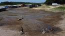 Warga berjalan di dekat sumur yang ia gali di dasar danau Puraquequara yang kering untuk mendapatkan air di tengah kekeringan parah, di Manaus, negara bagian Amazonas, Brasil, Kamis, 5 Oktober 2023. (AP Photo/Edmar Barros)