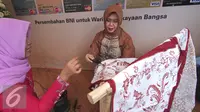 Corporate Secretary BNI Tribuana Tunggadewi saat membuat batik tulis dalam Peringatan Hari Batik Nasional di Museum Tekstil, Jakarta, Jumat (2/10/2015). Perayaan tersebut menampilkan produk batik berbagai daerah di Indonesia. (Liputan6.com/Angga Yuniar)
