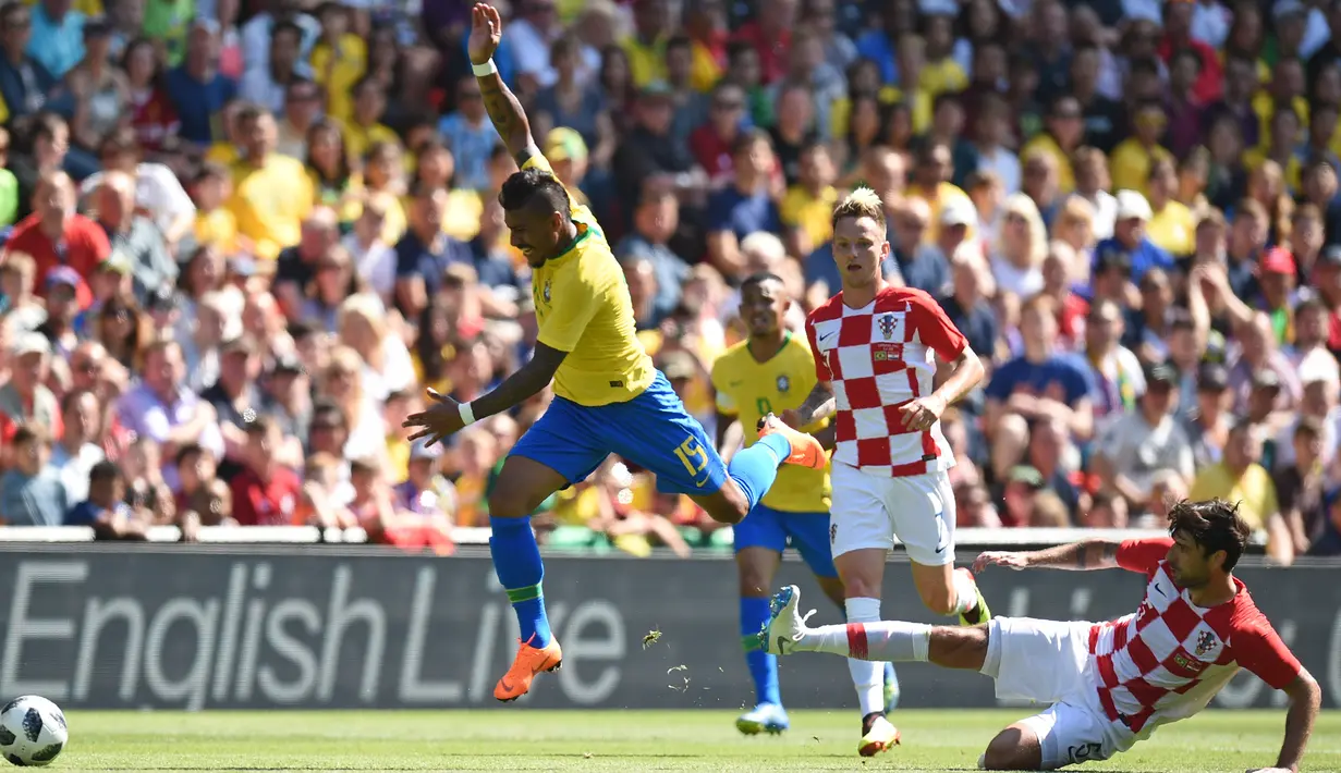 Gelandang Brasil, Paulinho, menghindari tekel bek Kroasia, Vedran Corluka, pada laga persahabatan di Stadion Anfield, Liverpool, Minggu (3/6/2018). Brasil menang 2-0 atas Kroasia. (AFP/Oli Scarff)