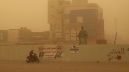 Seorang pria mengendarai skuternya di jalan selama badai debu di kota Nasiriyah Irak di provinsi Dhi Qar selatan (9/4/2022). Badai debu telah melanda sebagian besar Irak, meninggalkan puluhan orang di rumah sakit dengan masalah pernapasan. (AFP/Shwan Nawzad)