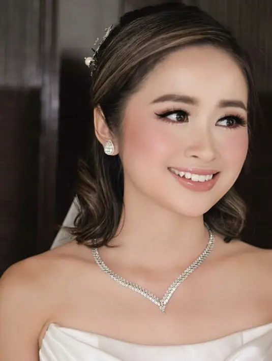 Gritte pun semakin memukau dengan veil putih yang menghias rambutnya serasi dengan aksesori dari Komang Tri Jewellery. Ditambah dengan perhiasan mewah dari kalung dan anting-anting ya. [@victoria_makeupatelier]