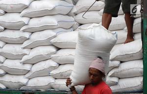 Seorang kuli angkut menurunkan beras dari atas truk di Pasar Induk Cipinang, Jakarta, Senin (25/9). Pedagang beras Cipinang sudah menerapkan dan menyediakan beras medium dan beras premium sesuai harga eceran tertinggi (HET). (Liputan6.com/Angga Yuniar)