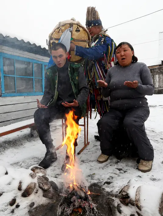 Seorang dukun melakukan ritual bersama dua pelanggan untuk mengusir roh-roh jahat di kediamannya di Kota Kyzyl, Tuva, Siberia, Rusia, (3 /11). (REUTERS/Ilya Naymushin)