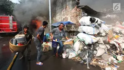 Warga mengangkut barang-barang berharga saat kebakaran melanda sebuah gudang di Jalan Kampung Bandan, Ancol, Jakarta Utara, Kamis (5/7). Kebakaran terjadi pada pukul 13.25 WIB. (Kapanlagi.com/Budy Santoso)