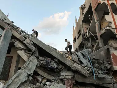 Warga Palestina memeriksa reruntuhan bangunan yang terkena serangan Israel di kamp pengungsi Nuseirat di Jalur Gaza tengah, pada 25 September 2025. (Eyad BABA/AFP)