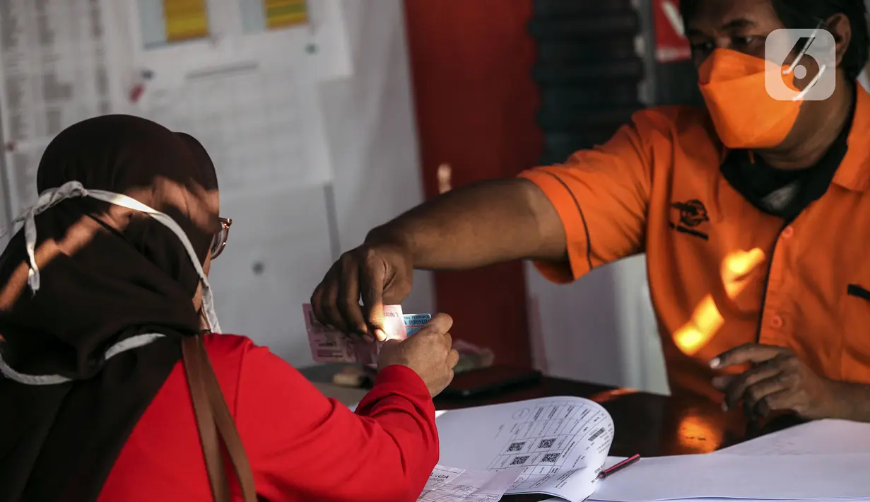 Warga menerima uang bantuan sosial (bansos) di kawasan Kedoya Selatan, Jakarta Barat, Rabu (28/7/2021). Bansos berupa uang tunai sebesar Rp 600 ribu tersebut disalurkan oleh PT. Pos Indonesia. (Liputan6.com/Johan Tallo)