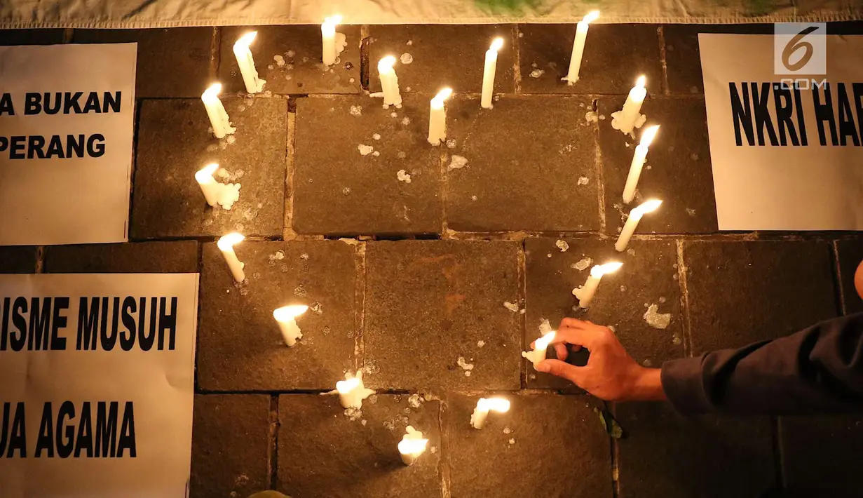 Lilin simbol cinta dinyalakan oleh gabungan suporter klub sepak bola dalam aksi solidaritas terkait tragedi teror bom di Surabaya dan Sidoarjo di Taman Suropati, Jakarta, Senin (14/5). (Liputan6.com/Immanuel Antonius)