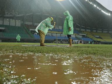 Petugas membuat lubang resapan untuk menguras air yang menggenangi lapangan di Stadion Patriot, Bekasi, Senin (13/11/2017). Drainase yang buruk menyebabkan lapangan terendam air. (Bola.com/M Iqbal Ichsan)