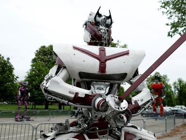Sebuah robot memegang sebuah pedang dipamerkan di kota Zagreb, Kroasia (18/4). Robot yang terbuat dari mobil bekas ini terlihat mirip karakter film Transformers yang merupakan karya seniman muda asal Montenegro, Danilo Baletic. (REUTERS/Antonio Bronic)