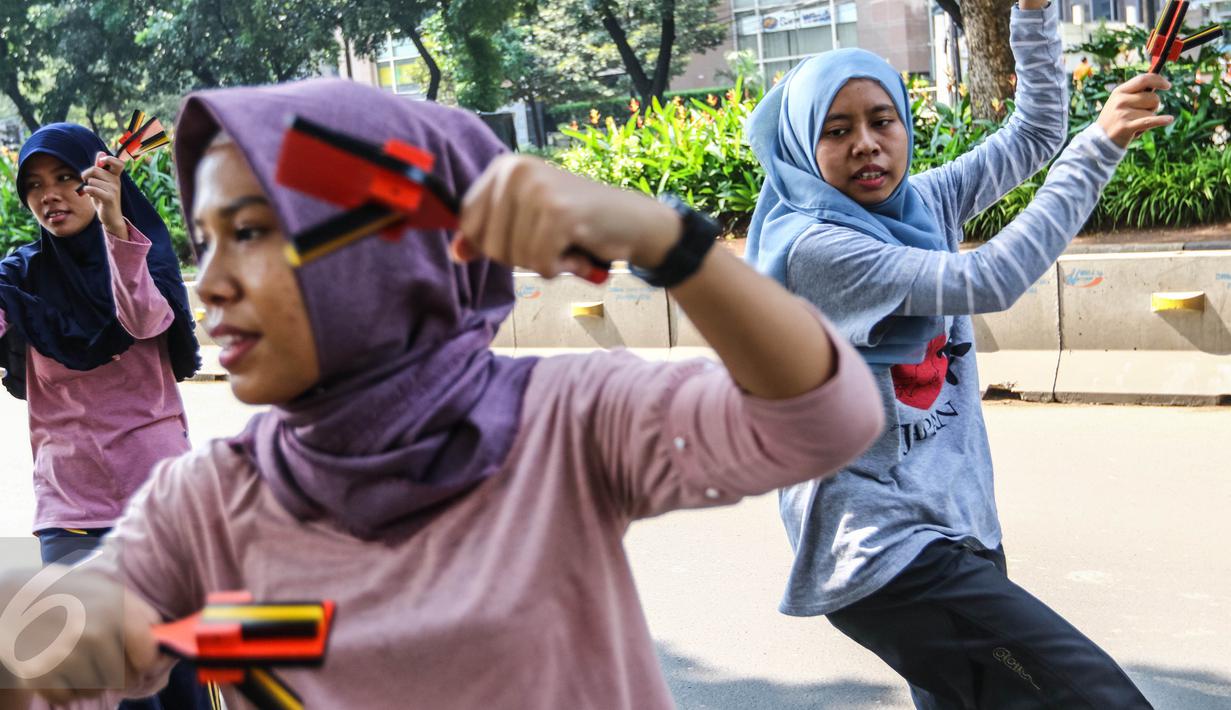 Anak muda yang tergabung dalam komunitas Hyakka Ryouran berlatih alat musik tradisional asal Jepang, Naruko, di kawasan Senayan, Jakarta, Minggu (24/7). Warna alat musik Naruko didominasi warna oranye, kuning dan hitam. (Liputan6.com/Fery Pradolo)