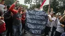 Puluhan driver online membentangkan spanduk saat unjuk rasa di depan Kemenhub, Jakarta, Senin (22/1). Dalam aksinya mereka menolak PM 108 Tahun 2017 mengenai besaran tarif yang harus sesuai dengan agrometer taksi daring.  (Liputan6.com/Faizal Fanani)