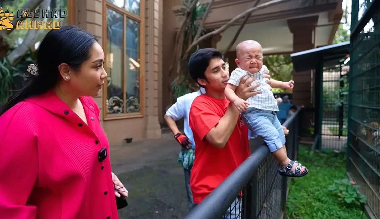 Tapi lama-lama, bayi berusia delapan bulan ini malah menangis. Alshad pun membawa Rayyanza menjauh dari kandnag harimaunya. (Foto: YouTube Alshad Ahmad)