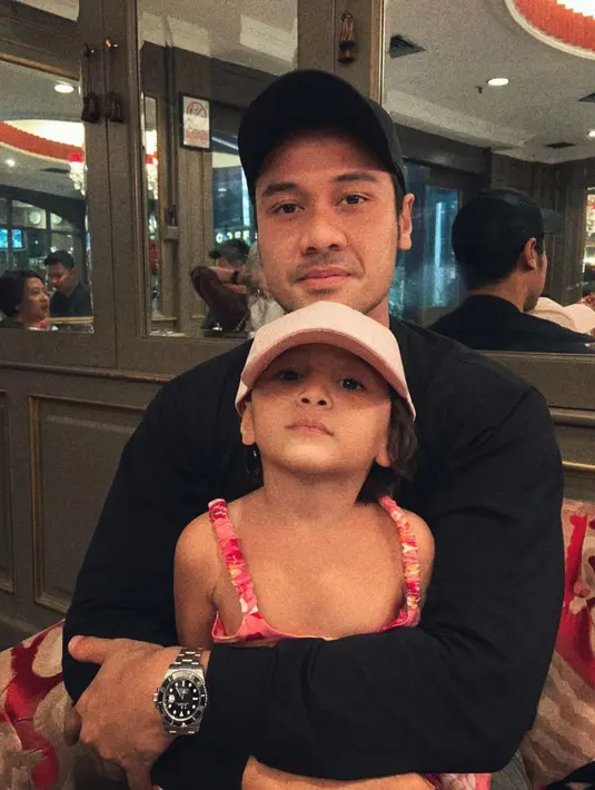 Chicco Jerikho dan Surinala kompak memakai topi. Dalam foto ini, ayah dan anak tersebut terlihat sangat mirip. (Foto: Instagram/ chicco.jerikho)