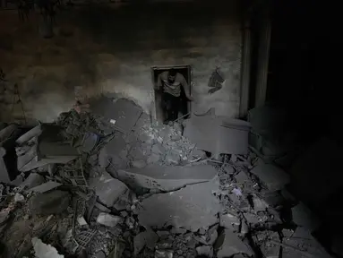 Seorang pria memeriksa kondisi apartemennya di lokasi bangunan yang hancur akibat serangan udara Israel di kota pelabuhan Tyre, Lebanon selatan, Kamis, 26 Maret 2026. Eskalasi serangan militer Israel ke Lebanon terus meningkat dalam beberapa hari terakhir. (AP Photo/Hussein Malla)