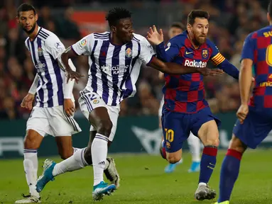 Megabintang Barcelona, Lionel Messi, mengontrol bola melewati hadangan pemain Real Valladolid, Mohammed Salisu dalam pertandingan pekan ke-11 La Liga  di Camp Nou, Selasa (29/10/2019). Barcelonamenutup laga dengan kemenangan 5-1 lewat gol tambahan dari Lionel Messi dan Luis Suarez. (AP/Joan Monfort)