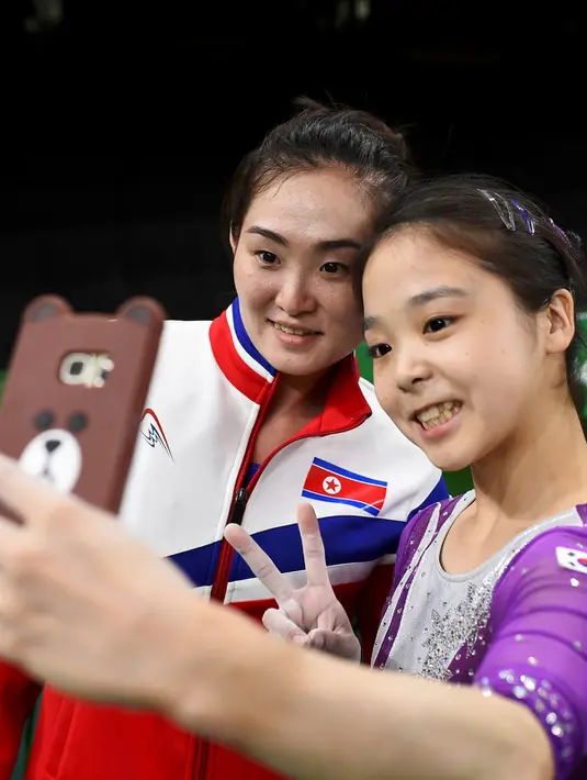 Atlet senam asal Korea Selatan, Lee Goim (kanan) berfoto bersama dengan atlet senam asal Korea Utara Hong Un Jong saat berlatih jelang penampilannya di ajang Olimpiade 2016 di Rio Olympic Arena di Rio de Janeiro, Brazil, (4/8). (REUTERS/Dylan Martinez)