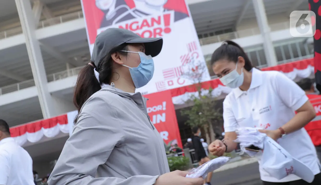 Warga mendapatkan masker saat kampanye Gerakan Masker Nasional "Jangan Kendor, Disiplin Pakai Masker" di Gelora Bung Karno, Jakarta (30/8/2020). Pembagian masker dan kampanye ini dilakukan mengantisipasi penyebaran lebih luas lagi virus covid-19. (Liputan6.com/Johan Tallo)