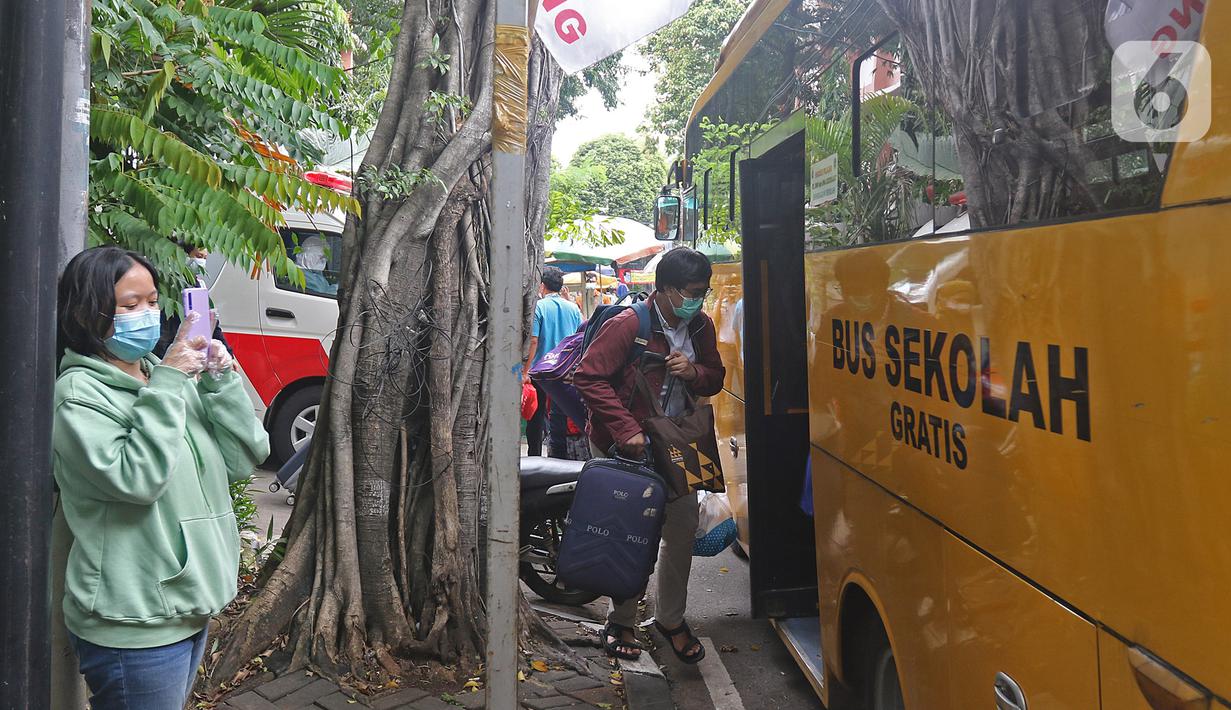 Sejumlah pasien Covid-19 Tanpa Gejala saat memasuki bus sekolah di Puskesmas Kecamatan Cilandak, Jakarta, Kamis (4/2/2021). Sehingga total kasus positif bertambah menjadi 1.123.105 orang. (Liputan6.com/Herman Zakharia)