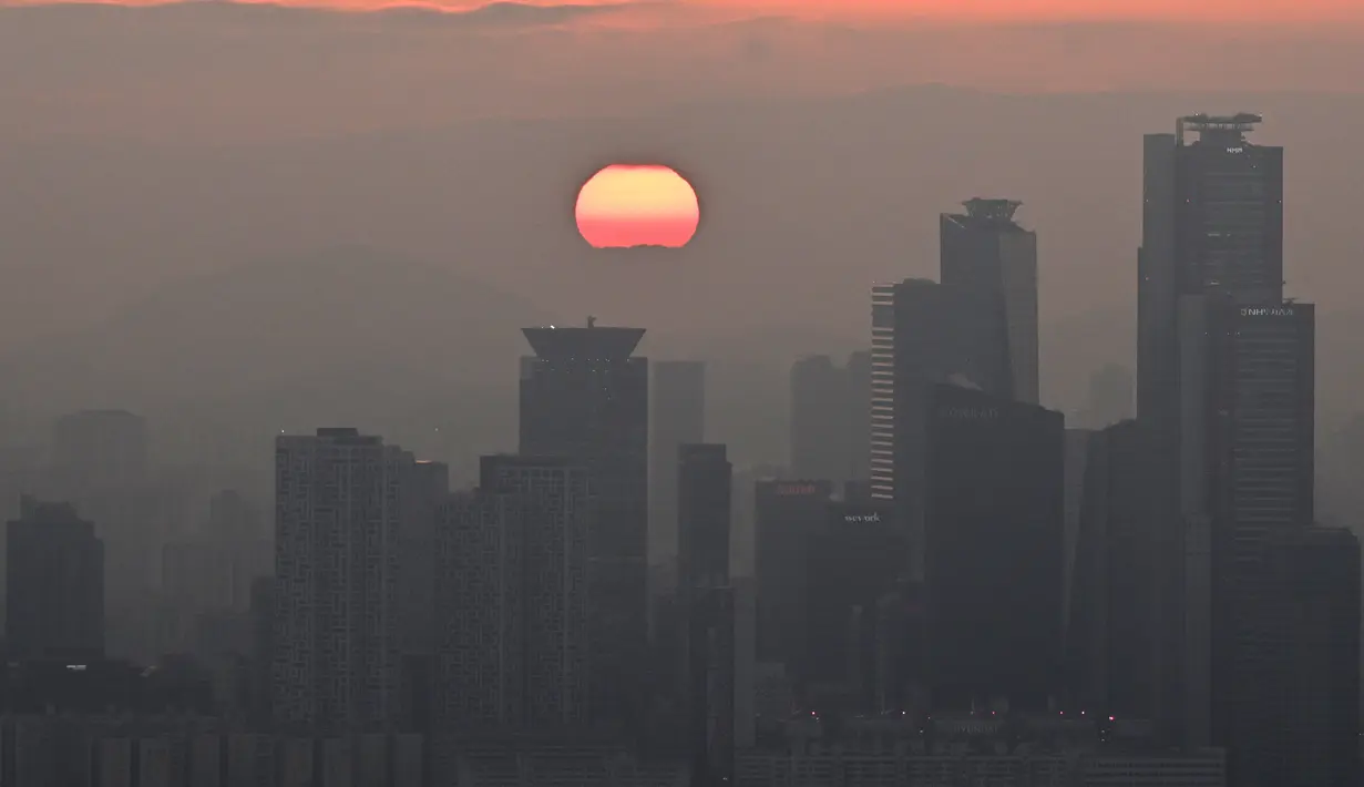 Pemandangan umum menunjukkan matahari terbenam terakhir tahun ini dari menara Namsan di Seoul, Korea Selatan, Minggu (31/12/2023). (Jung Yeon-je / AFP)