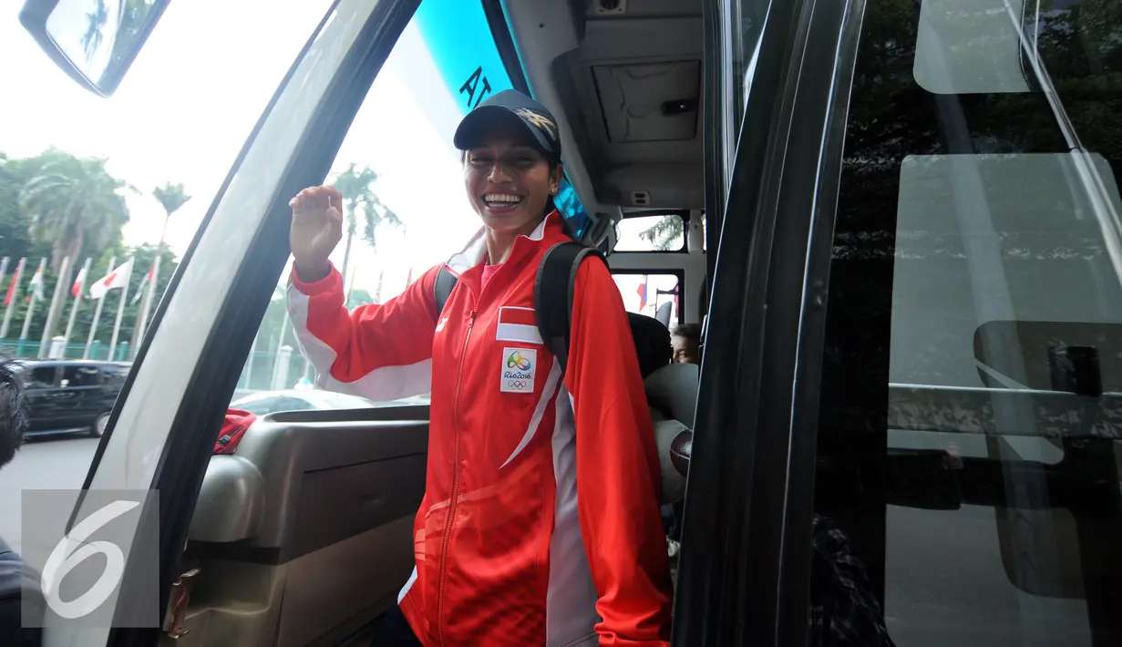 Atlet Lompat Jauh Indonesia, Maria Londa melambaikan tangan saat masuk ke dalam bus usai pelepasan di gedung KOI Jakarta, Rabu (27/7). Maria akan berlaga di Olimpiade Rio 2016 dan menjadi pembawa Bendera Merah Putih. (Liputan6.com/Helmi Fithriansyah)