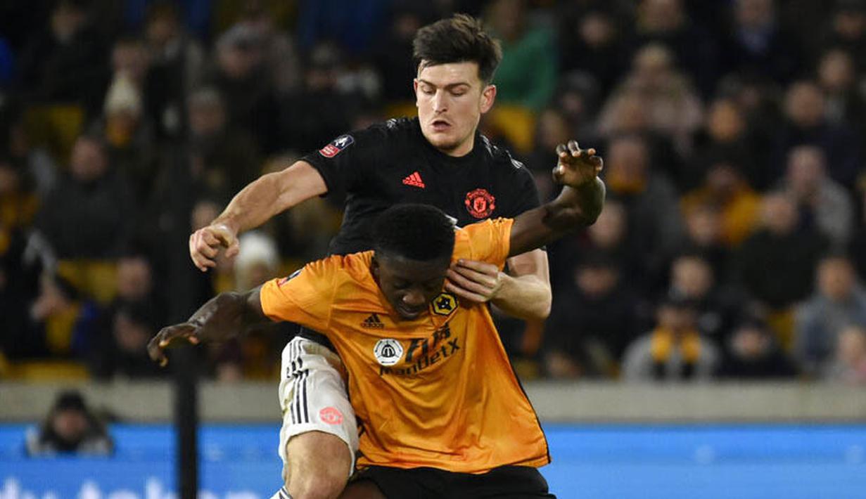 Bek Manchester United, Harry Maguire, mengawal pemain Wolverhampton Wanderers, Benny Ashley-Seal, pada laga Piala FA di Stadion Molineux, Sabtu (4/1/2020). Kedua tim bermain imbang 0-0. (AP/Rui Vieira)