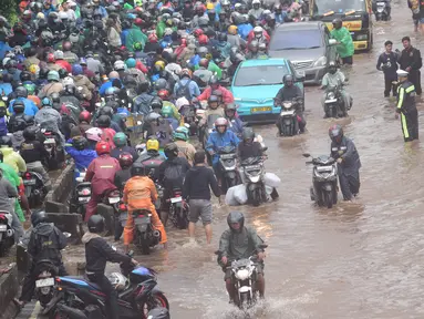 Antrean pengendara motor yang mencoba menerobos banjir di Jalan Daan Mogot, Jakarta, Jumat (23/1/02026). Hingga Jumat 23 Januari 2026 pagi, ruas Jalan Daan Mogot, Jakarta Barat, terendam banjir dengan ketinggian 30 hingga 50 cm. (merdeka.com/ Arie Basuki)