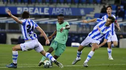 Pemain Real Madrid, Vinicius Junior, berusaha melewati pemain Real Sociedad pada laga La Liga di Reale Seguros Stadium, Minggu (21/6/2020). Real Madrid menang 2-1 atas Real Sociedad. (AP Photo/Alvaro Barrientos)
