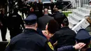 Polisi menggelandang pengunjuk rasa wanita yang tampil topless di sidang kekerasan seksual komedian Bill Cosby, Pennsylvania, AS, Senin (9/4). (AP Photo/Corey Perrine)