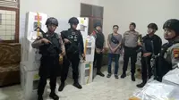 Personel Polres Kampar dan Brimob Polda Riau mengecek gudang di kantor desa untuk memastikan distribusi logistik Pemilu 2024 lancar. (Liputan6.com/M Syukur)