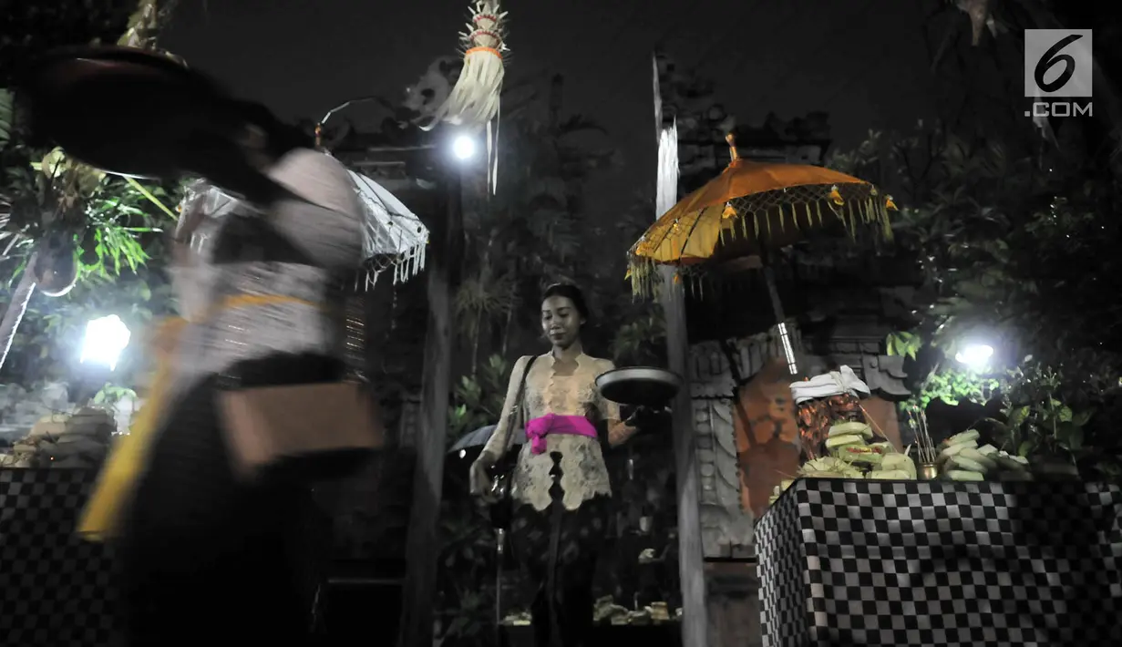Umat Hindu membawa sesaji saat akan melaksanakan sembahyang malam (Tilem Kesanga) menjelang Nyepi Tahun Baru Saka 1941 di Pura Aditya Jaya, Jakarta, Rabu (6/3). (merdeka.com/Iqbal S Nugroho)