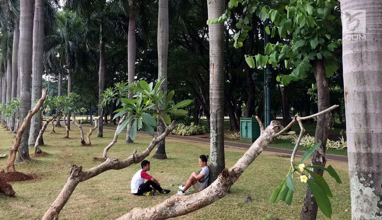 Pengunjung bersantai sambil bercengkerama di sekitar Taman Monas, Jakarta, Rabu (17/1). Pencabutan pagar Taman Monas mulai berlaku sejak Senin, 8 Januari 2018. (Liputan6.com/Immanuel Antonius)