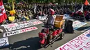 Seorang pedagang penyandang disabilitas menyampaikan pidato saat aksi protes menentang kenaikan harga Bahan Bakar Minyak (BBM) non-subsidi dan program Makan Siang Gratis (MBG) di Surabaya, Jawa Timur, Rabu 17 Juni 2026. (JUNI KRISWANTO/AFP)