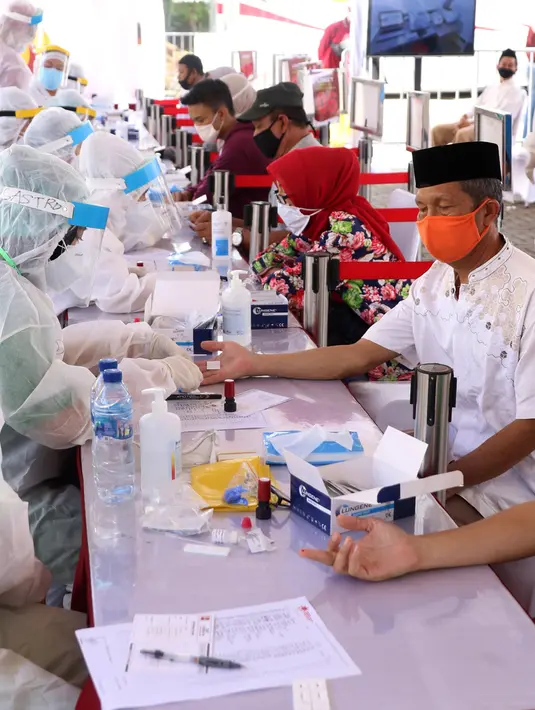 Petugas Medis mengambil sampel darah warga saat rapid test massal di Kota Tangerang, Banten, Sabtu (30/5/2020).  Badan Intelijen Negara (BIN) menggelar tes diagnostik cepat (rapid rest) massal kepada warga Ciledug sebagai salah satu upaya pengendalian transmisi COVID-19. (Liputan6.com/Angga Yuniar)