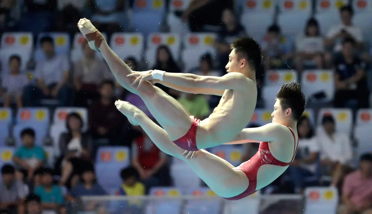 Aksi atlet loncat indah China, Lian Junjie dan Si Yajie saat tampil pada babak final platform sinkronisasi 10 meter campuran di Kejuaraan Renang Dunia, Gwangju, Korea Selatan, Sabtu (13/7/2019). (AP Photo/Lee Jin-man)