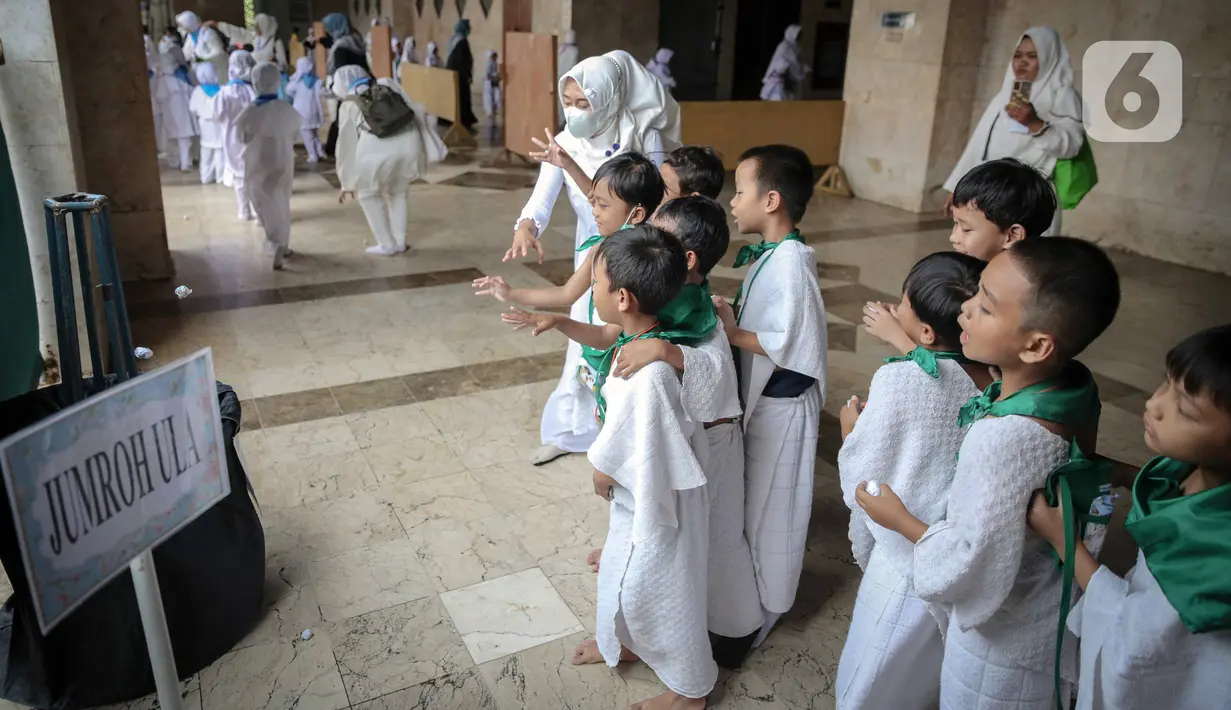 Murid TK melakukan simulasi lempar jumrah saat mengikuti edukasi manasik haji anak di Masjid At-Tin, Jakarta, Selasa (28/2/2023). Manasik haji yang diikuti puluhan murid TK se-Kecamatan Pasar Rebo tersebut dalam rangka mengenalkan rukun Islam kelima yakni ibadah haji serta tata cara melaksanakannya kepada anak sejak usia dini. (Liputan6.com/Faizal Fanani)