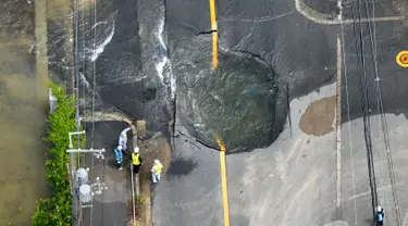 Air keluar dari retakan dan membanjiri jalan menyusul gempa bumi di Takatsuki, Osaka, Jepang, Senin (18/6). Gempa berkekuatan 6,1 SR menghantam Osaka pada Senin pagi. (Yohei/Nishimura/Kyodo News via AP)