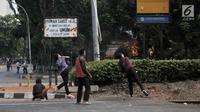 Massa melempari batu ke arah polisi saat Pos Polisi Subsektor Pejompongan terbakar dalam demonstrasi yang berujung bentrok di Jakarta, Rabu (25/9/2019). Pos Polisi Subsektor Pejompongan yang berada dekat lokasi bentrok terbakar hingga menghanguskan bangunan. (merdeka.com/Iqbal Nugroho)