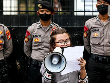 Seorang buruh migran berorasi di depan polisi saat menggelar aksi di depan Kedutaan Besar Malaysia, Jakarta, Selasa (9/8/2022). Mereka menuntut pemerintah Malaysia melakukan perbaikan dan menghentikan berbagai praktik kejam di dalam pusat tahanan imigrasi. (Liputan6.com/Faizal Fanani)