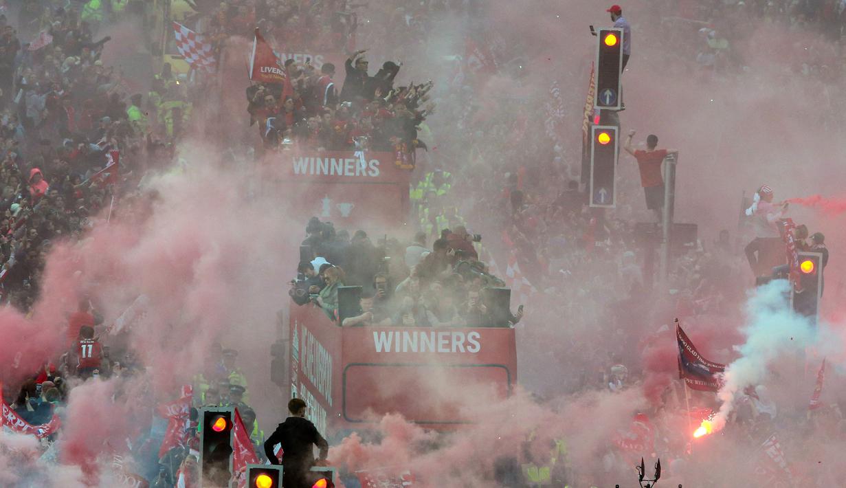 Ribuan fans Liverpool memadati jalan-jalan kota untuk menyambut tim kebanggaan mereka yang melakukan parade di atas bus terbuka pada Minggu (29/05/2022) waktu setempat. Musim ini, The Reds berhasil meraih dua trofi yaitu Piala FA dan Piala Liga Inggris. (AFP/Nigel Roddis)