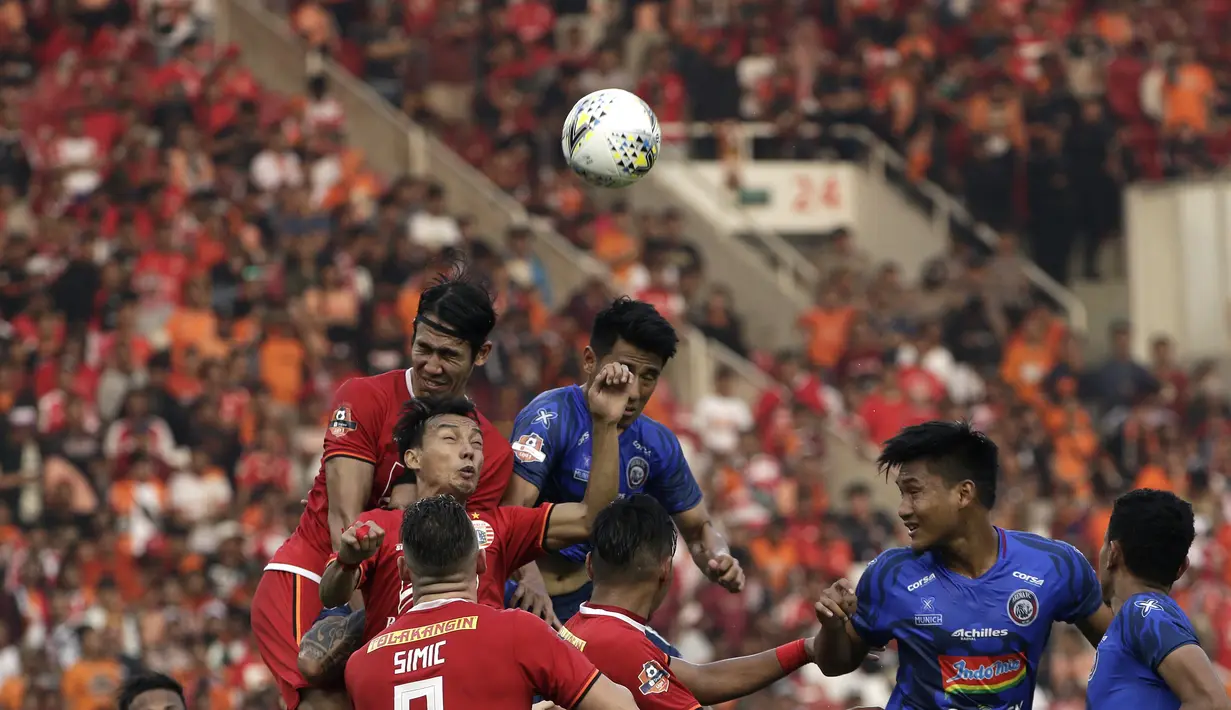 Bek Persija Jakarta, Ryuji Utomo, berebut bola atas dengan pemain Arema FC pada laga Shopee Liga 1 di SUGBK, Jakarta, Sabtu (3/8). Persija bermain imbang 2-2 atas Arema. (Bola.com/Yoppy Renato)