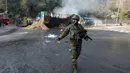 Seorang tentara India berjalan melewati lokasi baku tembak di Nagrota, Jammu-Srinagar, Kashmir yang dikuasai India, 28 Desember 2022. Polisi di wilayah Kashmir yang dikuasai India mengatakan pasukan pemerintah menewaskan empat tersangka militan dalam baku tembak tersebut. (AP Photo/Channi Anand)