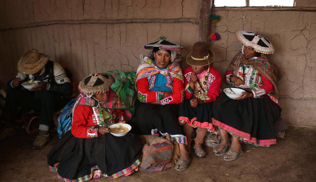 Wanita Andes setempat beristirahat makan siang di Gunung Pelangi di Pitumarca, Peru (5/4). Rainbow Mountain atau Gunung Pelangi memiliki warna-warni seperti pelangi ini memiliki ketinggian 16.404 kaki (5.000 meter) di Andes Peru. (AP Photo/Martin Mejia)