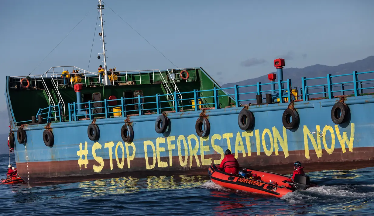 Aktivis Greenpeace melukis "Stop Deforestation Now" ke lambung kapal tanker minyak sawit di kilang Wilmar International di Bitung, Sulawesi Utara, Selasa (25/9). (Dhemas Reviyanto, Nugroho Adi Putera, Jurnasyanto Sukarno/Greenpeace Southeast Asia/AFP)