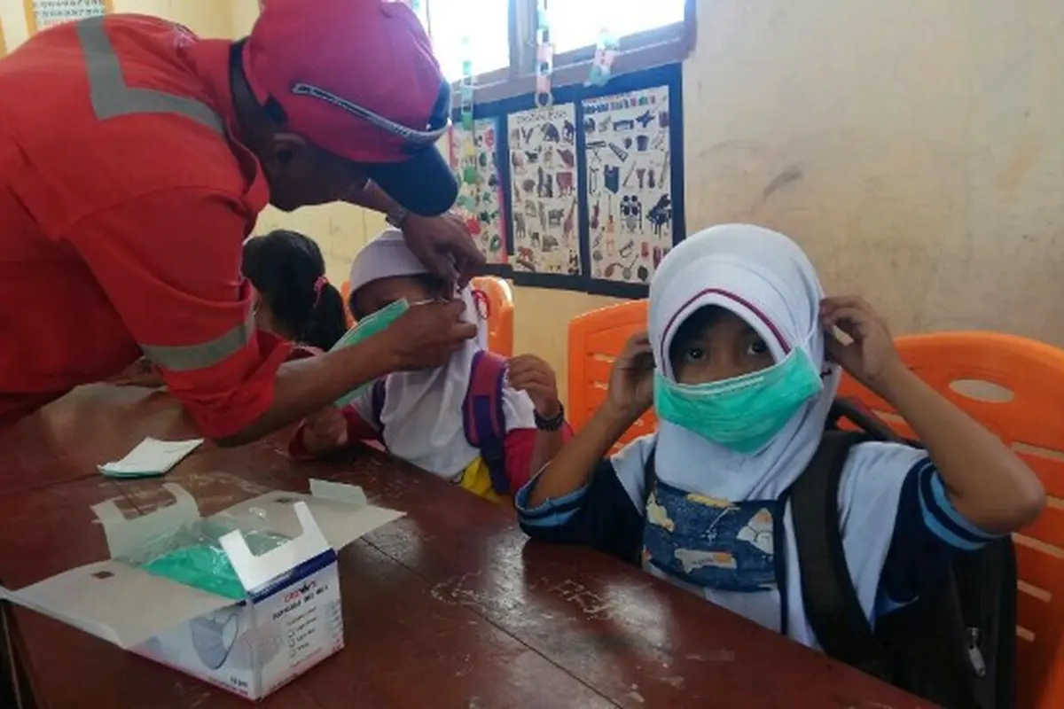 Murid SDN 29 Rupat dipasangi masker sebagai antisipasi jika kabut asap muncul lagi karena titik api masih ada
