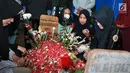 Kesedihan Ibu Julia Perez, Sri Wulansih saat sedang mendoakan di makam Julia Perez di TPU Pondok Ranggon, Jakarta, Selasa (13/6). Setelah mendoakan, Sri Wulansih beserta keluarga menaburkan bunga di makam Jupe. (Liputan6.com/Herman Zakharia)